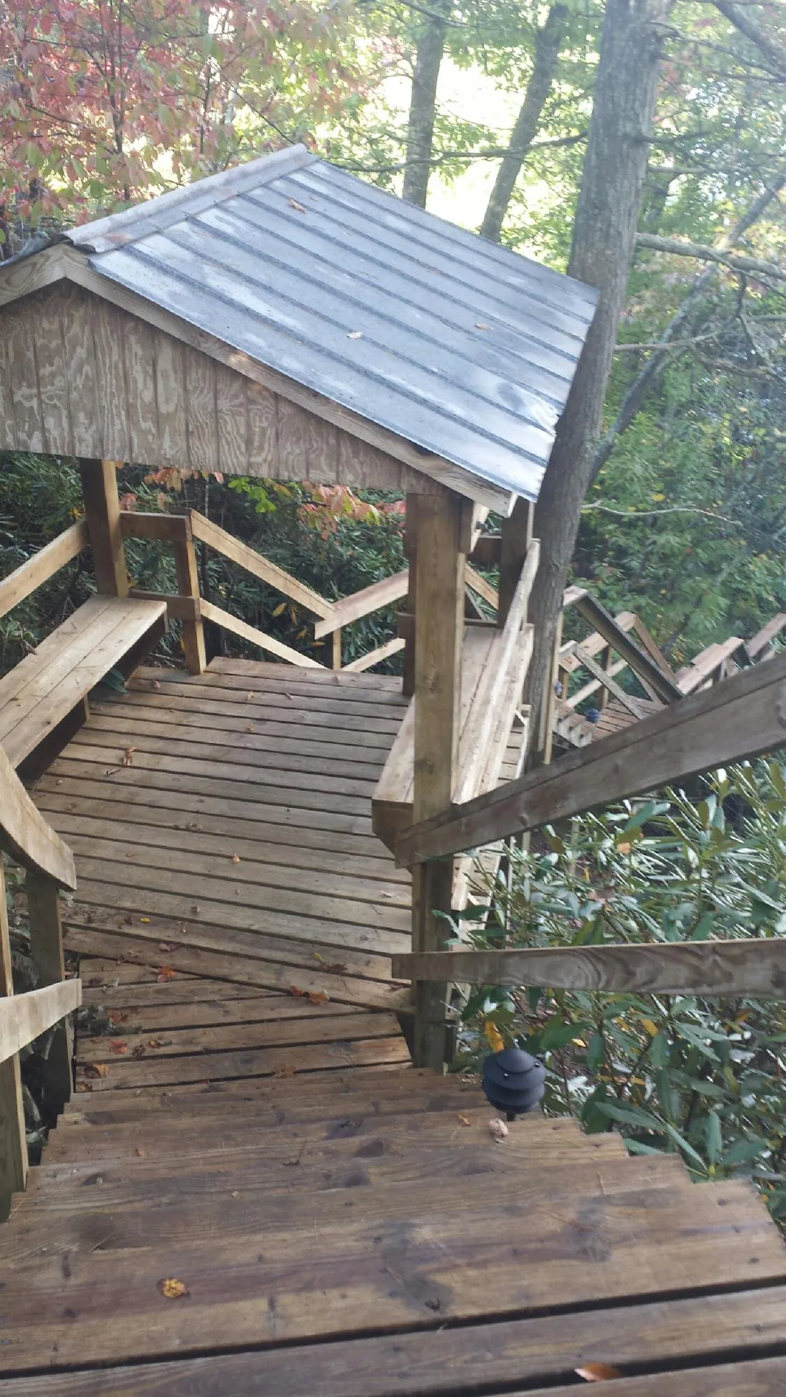 Metal roofed shelter over wooden steps on a wooded walkway — Skylight Repair & Installation work by our crew in Manchester